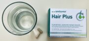amitamin Hair Plus mit zwei Kapseln und einem Glas Wasser zur täglichen Einnahme
